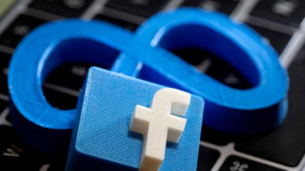 The logo of Facebook parent me<em></em>ta is beneath a 3D-printed logo of Facebook on a laptop keyboard in this illustration taken on November 2, 2021. Photo: Reuters