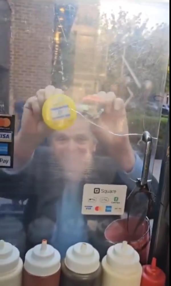 Seldowitz is pictured outside the halal cart holding up an Israeli flag pin.