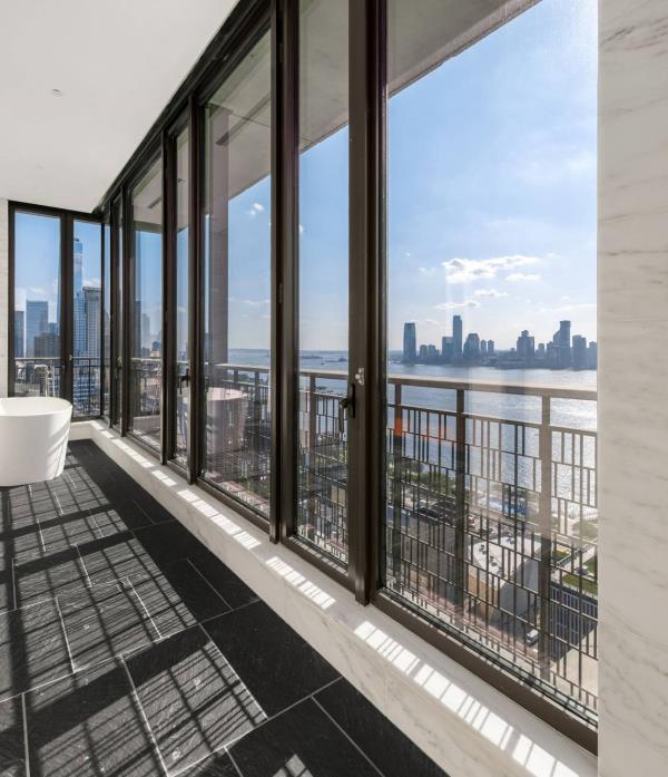  The unit’s primary bath, complete with soaking tub and floor-to-ceiling windows Photo: Edward Menashy for Evan Joseph Photography